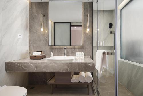 a bathroom with a sink and a mirror at Liz Hotel in Guangzhou