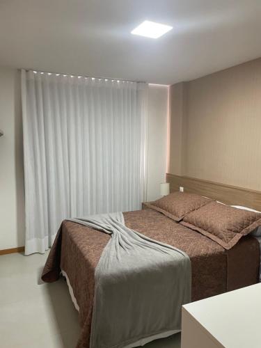sypialnia z 2 łóżkami i oknem w obiekcie Itacimirim Beira Mar w mieście Itacimirim
