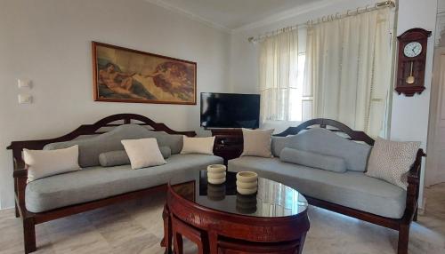 a living room with two couches and a coffee table at Fori's Nest Home SKG in Thessaloniki