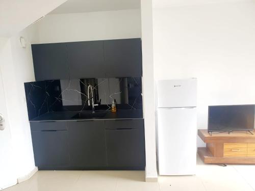 a kitchen with a sink and a refrigerator at Beachfront Hotel: Pool, Spa, wet/dry Sauna & Gym in Ashqelon