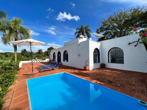 uma villa com piscina em frente a uma casa em Casa Mykonos Represa Avaré em Itaí