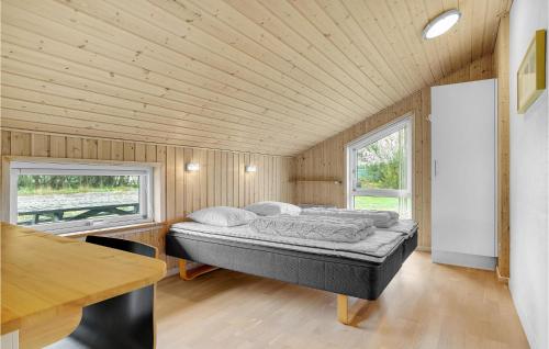 Jerupにある4 Bedroom Cozy Home In Jerupの木製の部屋にベッド1台が備わるベッドルーム1室があります。