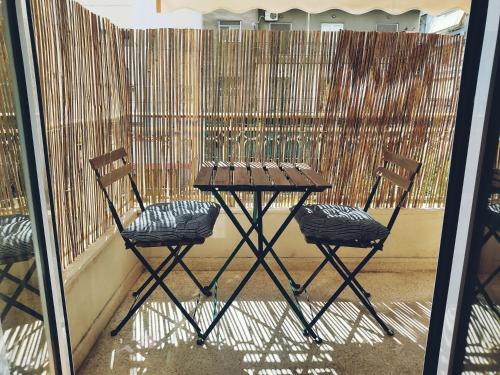 two chairs and a table in front of a fence at MimaDart Pop-up Gallery Apartment in Piraeus
