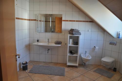 a bathroom with a sink and a toilet at Schnurs Ferienwohnung in Römerberg