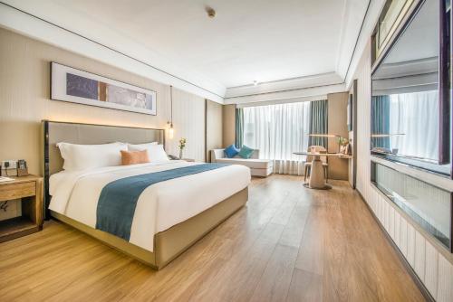 a hotel room with a large bed and a window at Liz Hotel in Guangzhou
