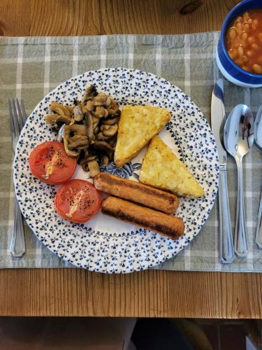 a plate of food with bread and tomatoes on a table at The Green Door Vegan B&B in Llanon