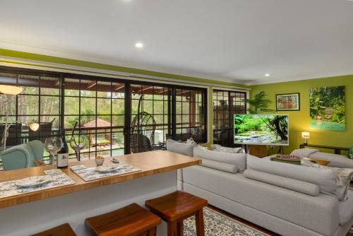 a living room with a couch and a table at Stylish rural retreat on the foothills of Mt. Mee in Upper Caboolture