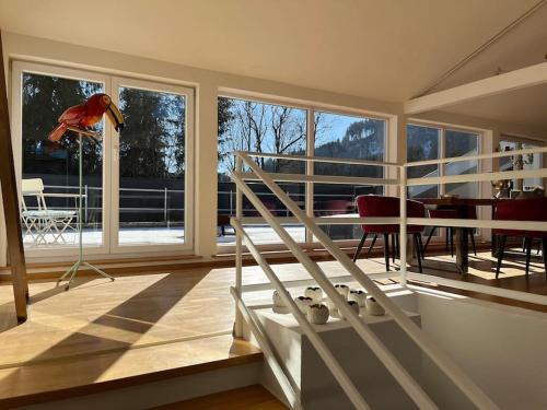 a room with a staircase and a table and chairs at Sonnige Loft mit Terrasse, Ladestation für Elektrofahrzeuge in Schindellegi