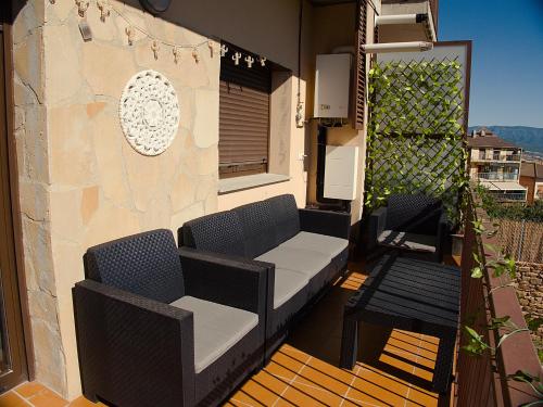 um pátio com 2 cadeiras e um banco numa varanda em Grace, apartamento con terraza y vistas em Talarn