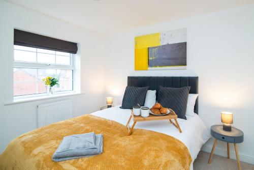 a bedroom with a bed with a tray of food on it at Pride Park House in Derby