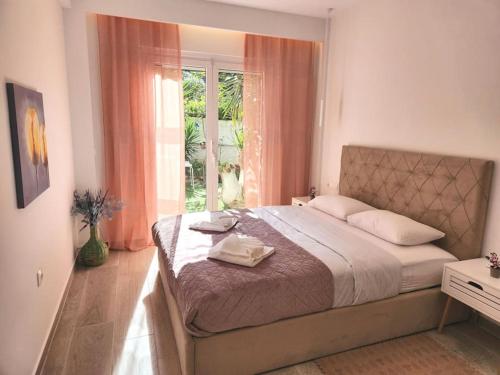 a bedroom with a large bed and a window at Nice Apartment near Flisvos in Athens