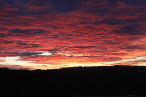 a sunset with red clouds in the sky at Relais De La Tour in Callac