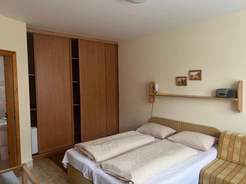 Un pequeño dormitorio con una cama y una silla. en Privát Pekný dvor, en Rajecké Teplice