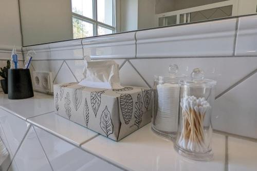 a white counter top with a box and tooth brushes at Stylisches Villa-Apartment in Schlossgartennähe in Schwerin