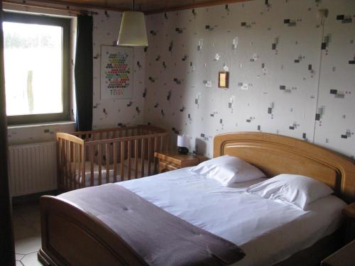 La Maison du Bonheur في Gouvy: غرفة نوم بسرير كبير وسرير أطفال