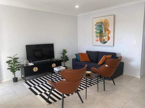 uma sala de estar com um sofá e duas cadeiras em Stylish 2Bed Close Airport/Shops em Perth