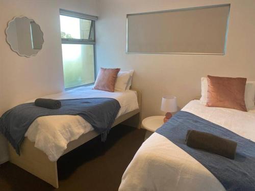 um quarto com 2 camas e uma janela em Stylish 2Bed Close Airport/Shops em Perth