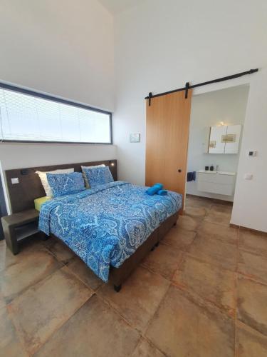 een slaapkamer met een bed en een groot raam bij Suites Sunny hill in Moncarapacho
