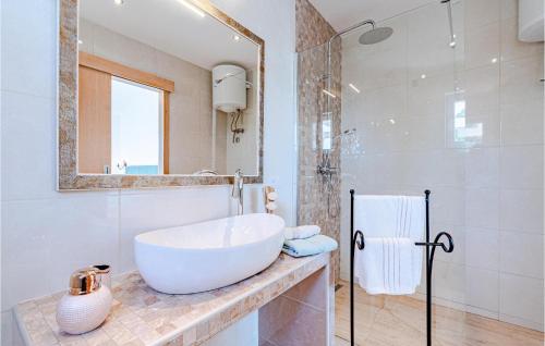a white bathroom with a sink and a mirror at Cozy Home In Dingac With Kitchen in Gornji Dingač