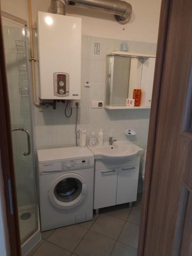 a bathroom with a washing machine and a sink at Startpunkt in Kołobrzeg