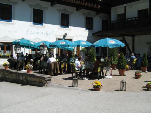 a group of people sitting at tables with blue umbrellas at Hotel Kammerhof in Mariastein