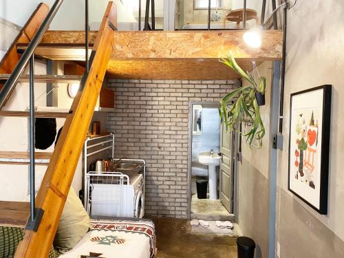 a room with a loft with a staircase and a bathroom at Hongdae Guesthouse Pajamaparty in Seoul