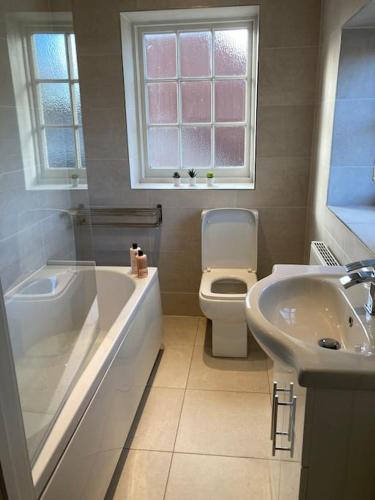 a bathroom with a tub and a toilet and a sink at In the heart of the new forest in Fordingbridge