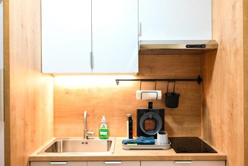 a kitchen counter with a sink and a microwave at Lena Apartman in Subotica