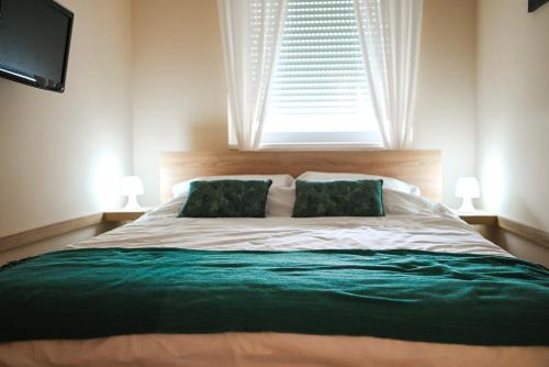 a bedroom with a large bed with a window at Lena Apartman in Subotica