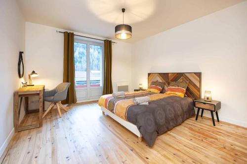 sypialnia z dużym łóżkiem, biurkiem i oknem w obiekcie Appartement Modane Gare Wifi stationnement gratuit w mieście Modane