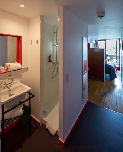 La salle de bains est pourvue d'un lavabo et d'une douche. dans l'établissement Hotel le Corbusier, à Marseille