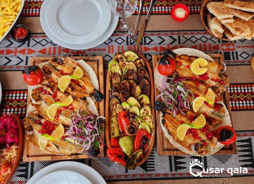 a table with many different types of food on it at Qusar Qala Hotel in Qusar