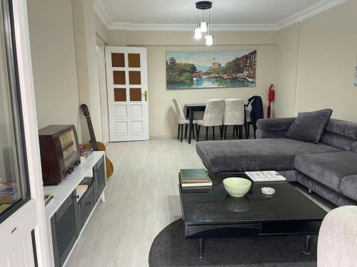 een woonkamer met een bank en een tafel bij Merkezi Çift Teraslı Ev in Istanbul