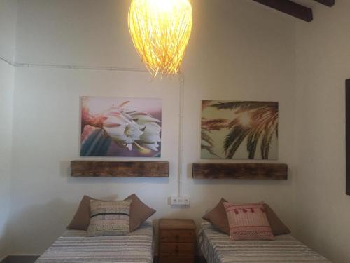 a bedroom with two beds and a chandelier at Vivienda vacacional Ladera Kalblanke junto Cabo de Palos 6 personas in Playa Honda