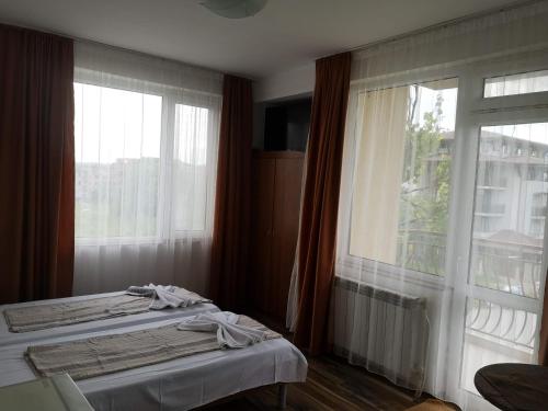a bedroom with two beds and a large window at Rooms Zora in Primorsko