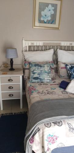 Sunridge ParkにあるSan-Lou Airbnbのベッドルーム1室(ベッド1台、ランプ付きテーブル付)