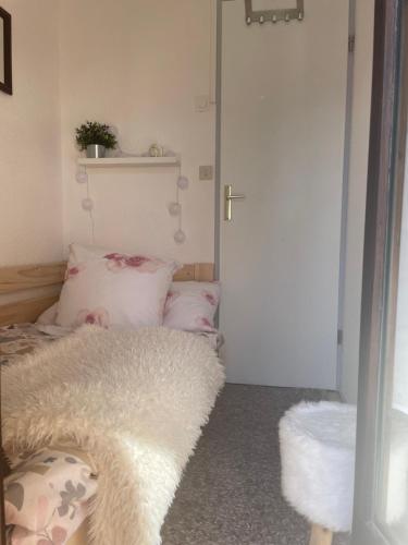 Habitación con cama y puerta con almohadas en Studio Turquoise quartier Grattague vue MontBlanc en Saint-Gervais-les-Bains