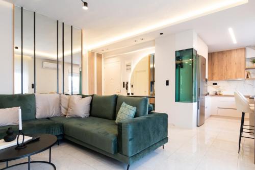 a living room with a green couch and a kitchen at Annecy in Alexandroupoli