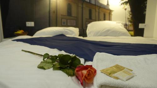 a bed with a rose and towels on it at Janowski Zakątek in Janów Lubelski