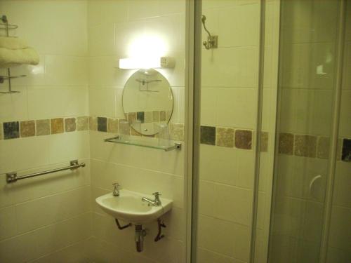 a bathroom with a sink and a shower with a mirror at Singlecote in Skegness