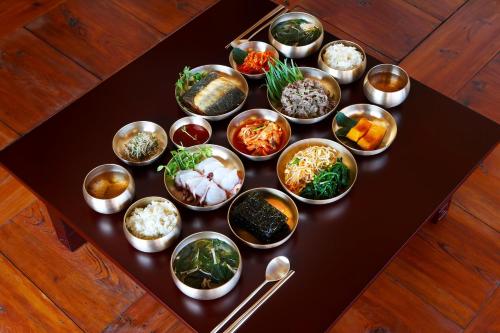 una mesa cubierta con cuencos de diferentes tipos de alimentos en Bukchondaek, en Andong