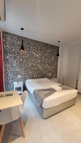1 dormitorio con 2 camas, mesa y pared en Casa Lemus, en Madrid