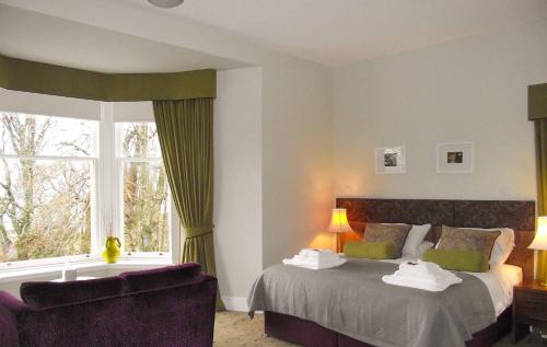 a bedroom with two beds and a couch and a window at Raasay House Hotel in Raasay