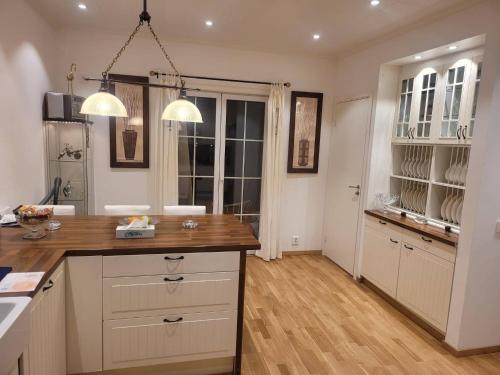 a kitchen with white cabinets and a wooden counter top at 2 bed room Quite and central house in Orebro in Örebro