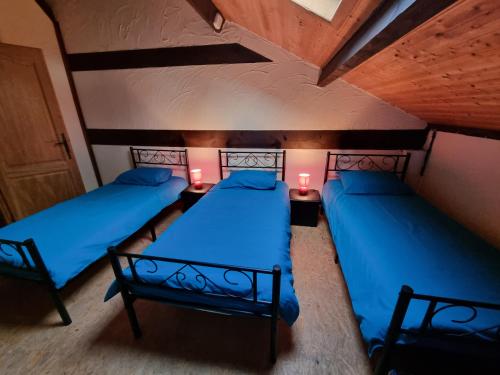 - 2 lits dans une chambre avec des draps et des lampes bleus dans l'établissement les gîtes d 'EVANE 