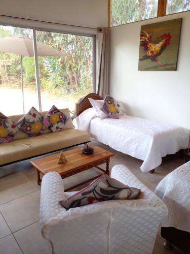 sala de estar con 2 camas y ventana en Cabaña La Quinta N 1, en Talca