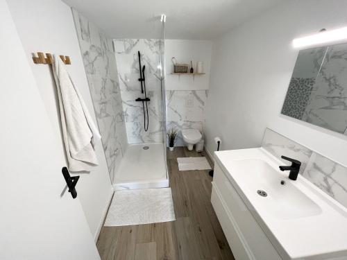 baño blanco con ducha y lavamanos en Dépendance T3 proches des plages en Lattes