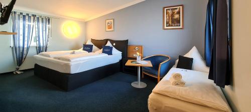 Donau-Hotel في Sinzing: غرفة فندقية بسريرين وطاولة