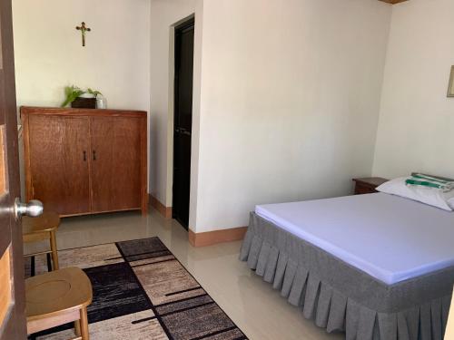 um quarto com uma cama e um armário de madeira em Airport View Hotel em Vigan