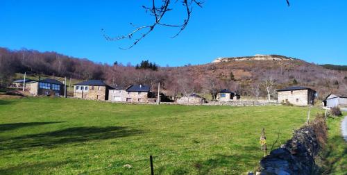 a field with houses and a hill in the background at O Busto Aldea Rural, Apartamento HORNO 2 
